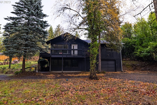 back of property with a garage and a wooden deck