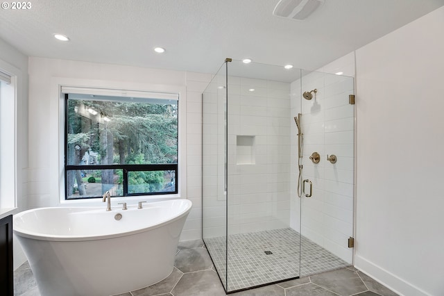 bathroom featuring tile floors, a textured ceiling, and independent shower and bath