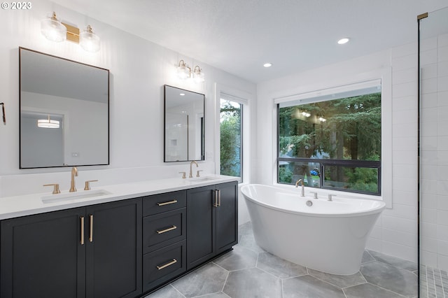 bathroom with tile walls, tile floors, double vanity, and a washtub