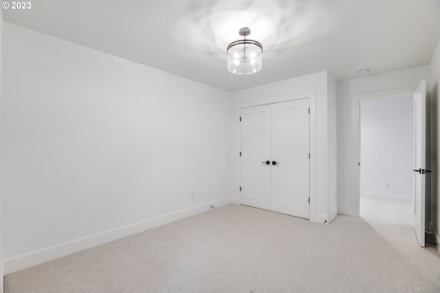 unfurnished bedroom with light carpet and a closet