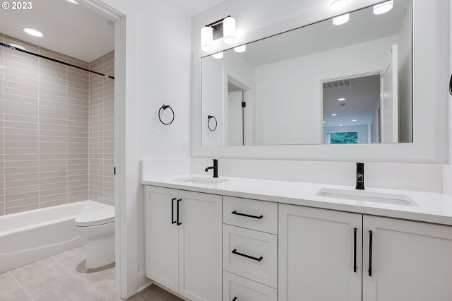 full bathroom with tile flooring, double sink vanity, toilet, and tiled shower / bath combo