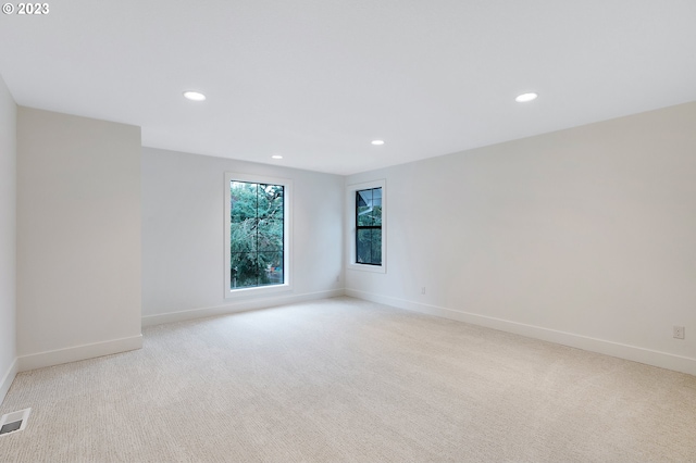 unfurnished room featuring light colored carpet