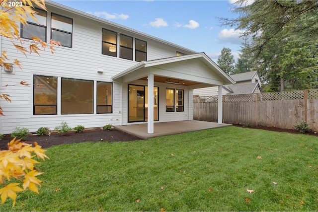 rear view of house featuring a patio and a lawn