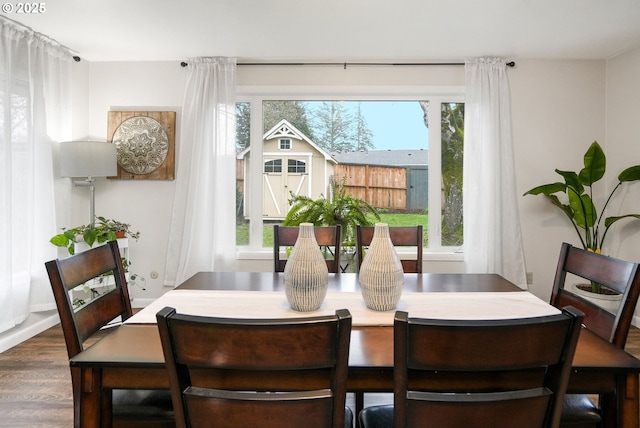 dining space with dark hardwood / wood-style flooring and a healthy amount of sunlight