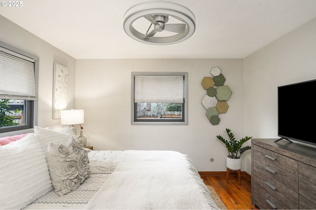 bedroom with dark hardwood / wood-style flooring and multiple windows