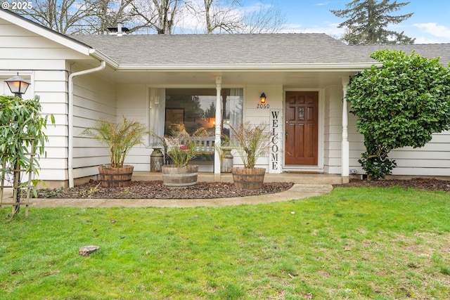 view of exterior entry with a yard