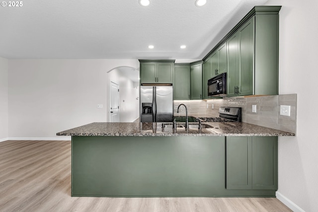 3707 NE Minnehaha St, Vancouver, WA 98661 - kitchen featuring appliances with stainless steel finishes, a peninsula, dark stone counters, and green cabinets