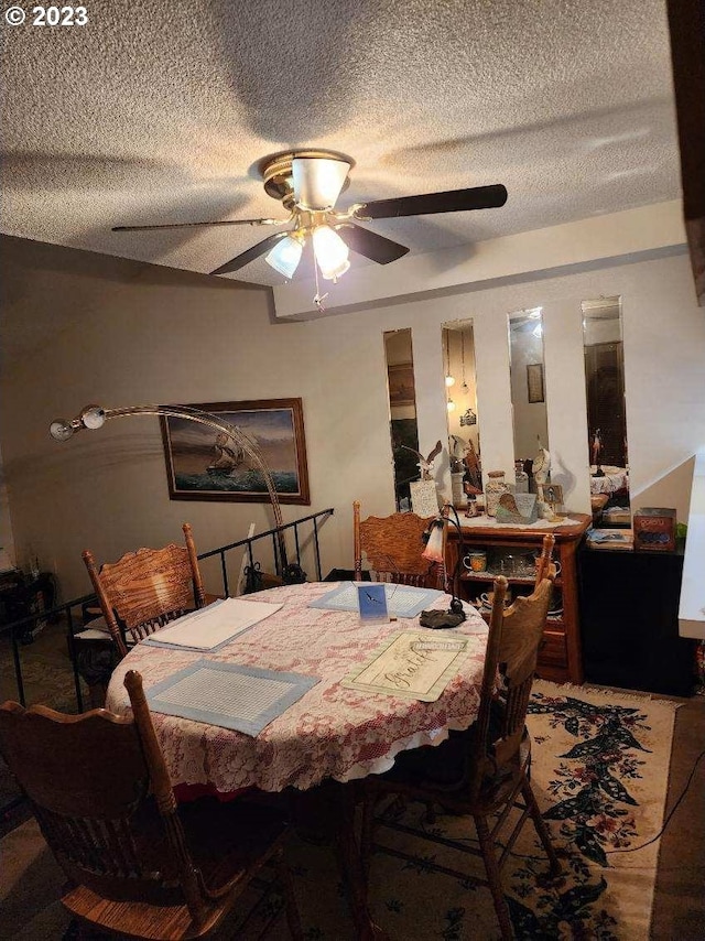 dining area with a textured ceiling and ceiling fan