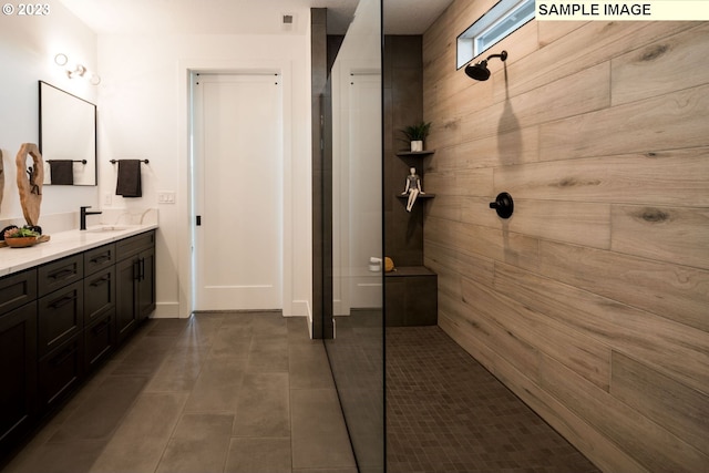 bathroom featuring a tile shower and vanity