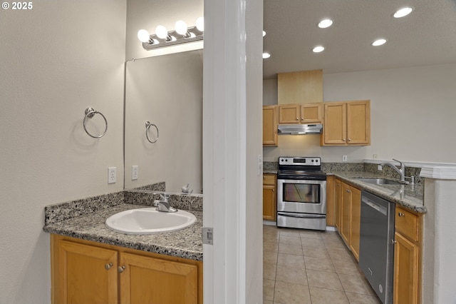 kitchen featuring under cabinet range hood, light tile patterned floors, appliances with stainless steel finishes, and a sink