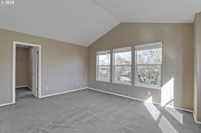 interior space with baseboards, carpet, and vaulted ceiling