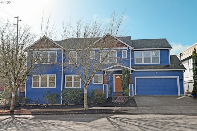 view of front facade featuring driveway, a shingled roof, and a garage