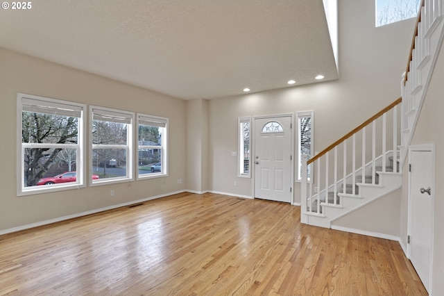 foyer featuring visible vents, wood finished floors, recessed lighting, baseboards, and stairs