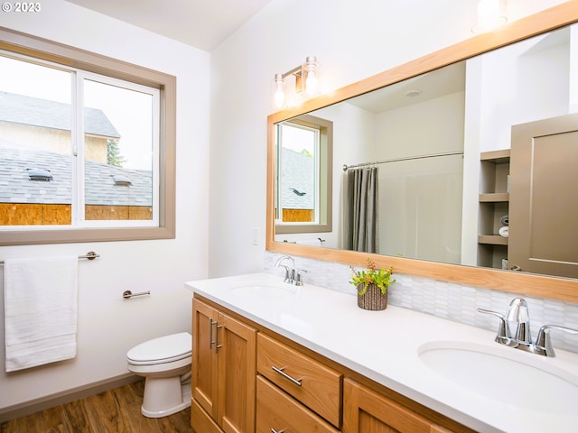 bathroom with double vanity, toilet, built in features, tasteful backsplash, and hardwood / wood-style flooring