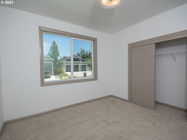 unfurnished bedroom with a closet and light colored carpet