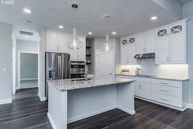 kitchen featuring dark hardwood / wood-style floors, an island with sink, hanging light fixtures, stainless steel appliances, and white cabinetry