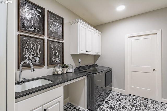 washroom with sink, cabinets, independent washer and dryer, and light tile flooring