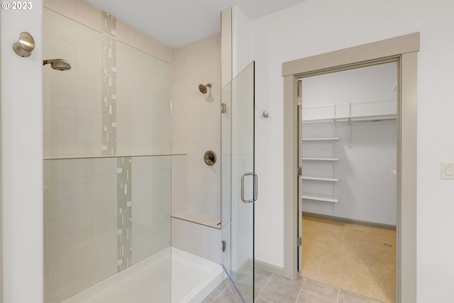 bathroom featuring a shower with door and tile flooring