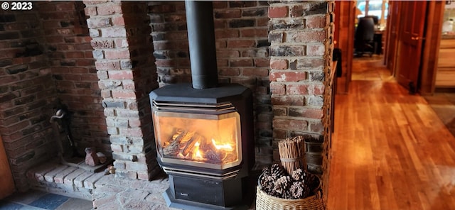 details with a wood stove and dark wood-type flooring