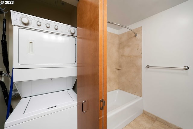 washroom featuring stacked washer / drying machine and light tile floors