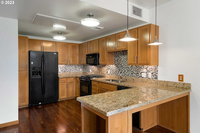 kitchen with hanging light fixtures, tasteful backsplash, kitchen peninsula, dark hardwood / wood-style floors, and black appliances