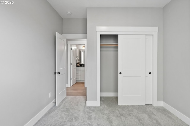 unfurnished bedroom with light carpet and a closet