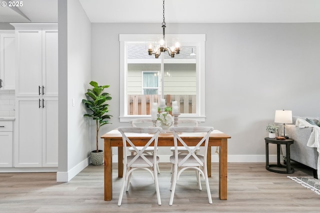 dining room featuring a notable chandelier and light wood-type flooring