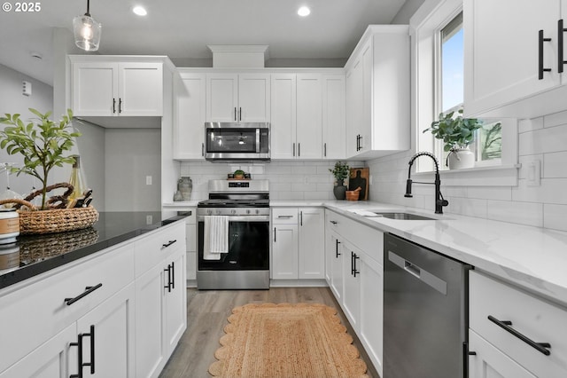 kitchen with white cabinetry, appliances with stainless steel finishes, and sink