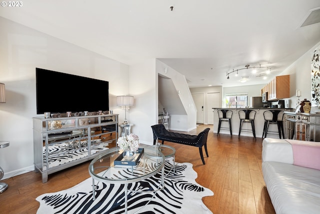 living room featuring hardwood / wood-style floors and rail lighting