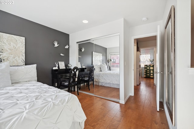 bedroom with dark hardwood / wood-style flooring and a closet