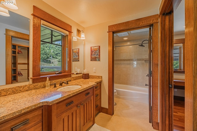 full bathroom featuring tiled shower / bath combo, oversized vanity, tile flooring, and toilet