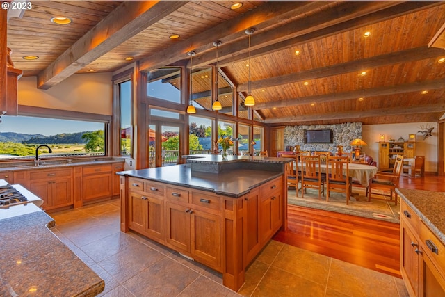 kitchen with dark stone counters, wood ceiling, a center island, vaulted ceiling with beams, and hardwood / wood-style flooring