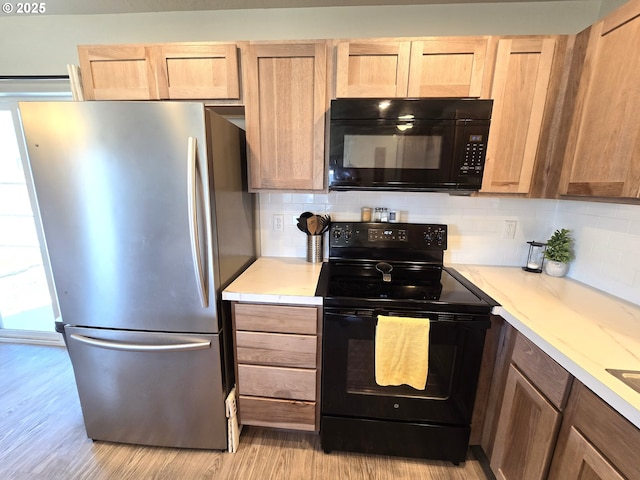 731 NE 11th St, Hermiston, OR 97838 - kitchen featuring black appliances, light wood finished floors, backsplash, and light brown cabinetry