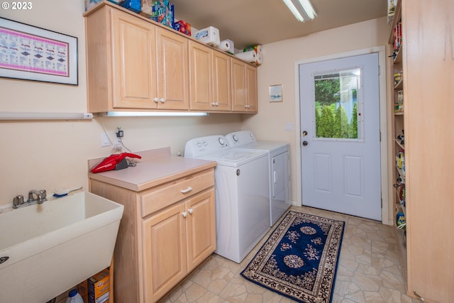 laundry room with sink, cabinets, washer and clothes dryer, and light tile floors