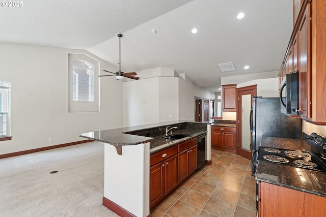 kitchen with black appliances, a sink, vaulted ceiling, a center island with sink, and a ceiling fan