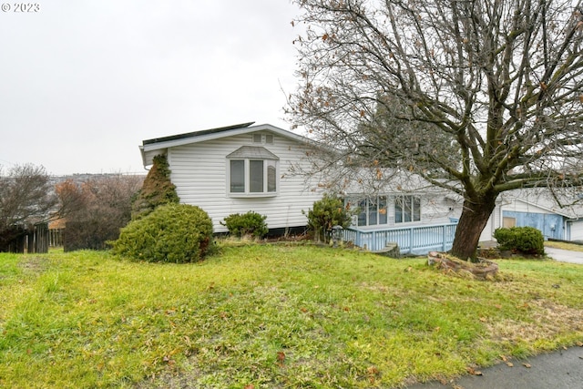 view of side of home with a yard