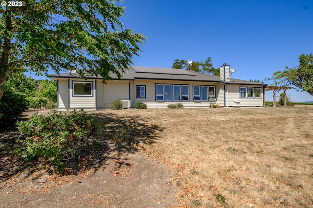 ranch-style home featuring solar panels