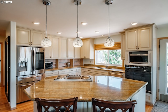 kitchen with a center island, light hardwood / wood-style floors, sink, and stainless steel appliances