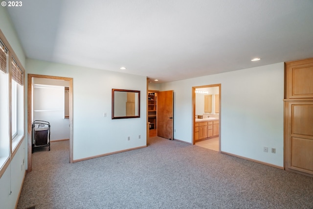 unfurnished bedroom with light colored carpet and ensuite bath