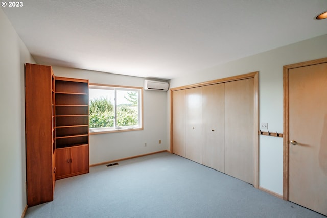 unfurnished bedroom featuring light colored carpet and an AC wall unit