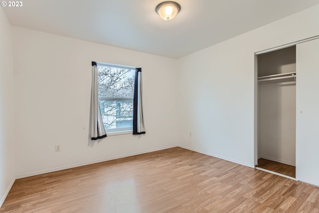 unfurnished bedroom with light hardwood / wood-style floors and a closet