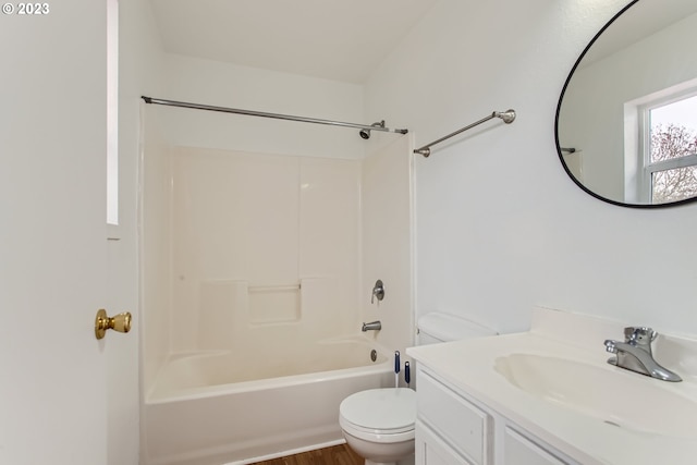 full bathroom featuring hardwood / wood-style floors, vanity, tub / shower combination, and toilet