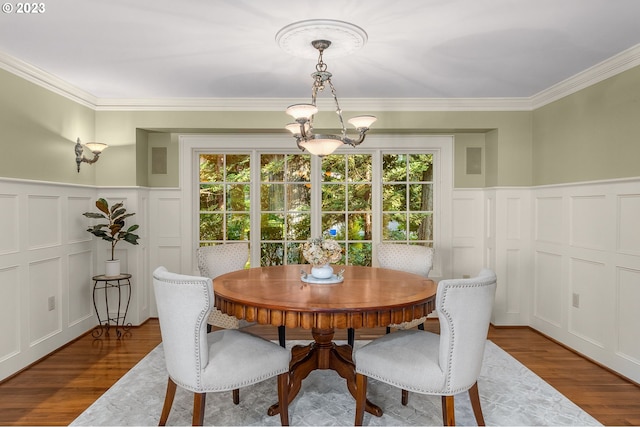 dining room with crown molding, a notable chandelier, a healthy amount of sunlight, and dark wood-type flooring