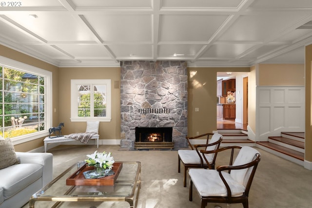 living room featuring coffered ceiling, carpet flooring, and a stone fireplace