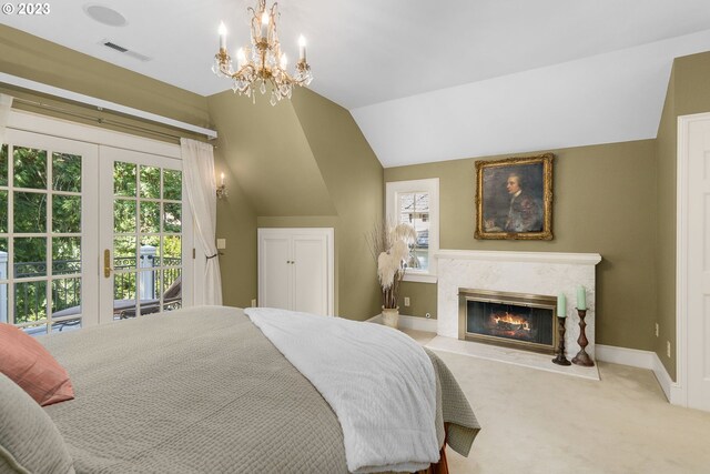 bedroom featuring carpet, a premium fireplace, a notable chandelier, access to exterior, and vaulted ceiling