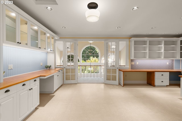 kitchen with white cabinetry, tasteful backsplash, and built in desk