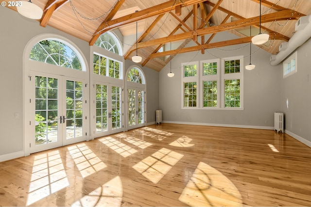 unfurnished room with beamed ceiling, high vaulted ceiling, light hardwood / wood-style floors, and french doors