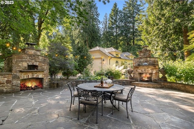 view of terrace with an outdoor stone fireplace