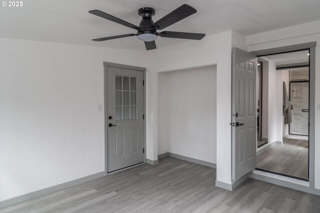 unfurnished room with baseboards, ceiling fan, and light wood-style floors