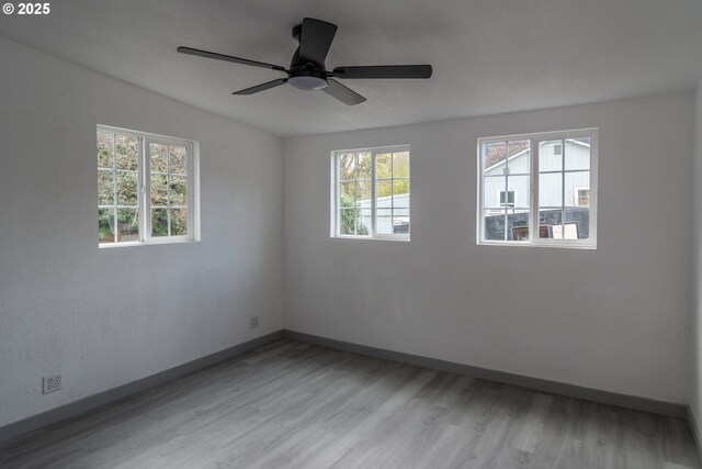 spare room with baseboards and wood finished floors